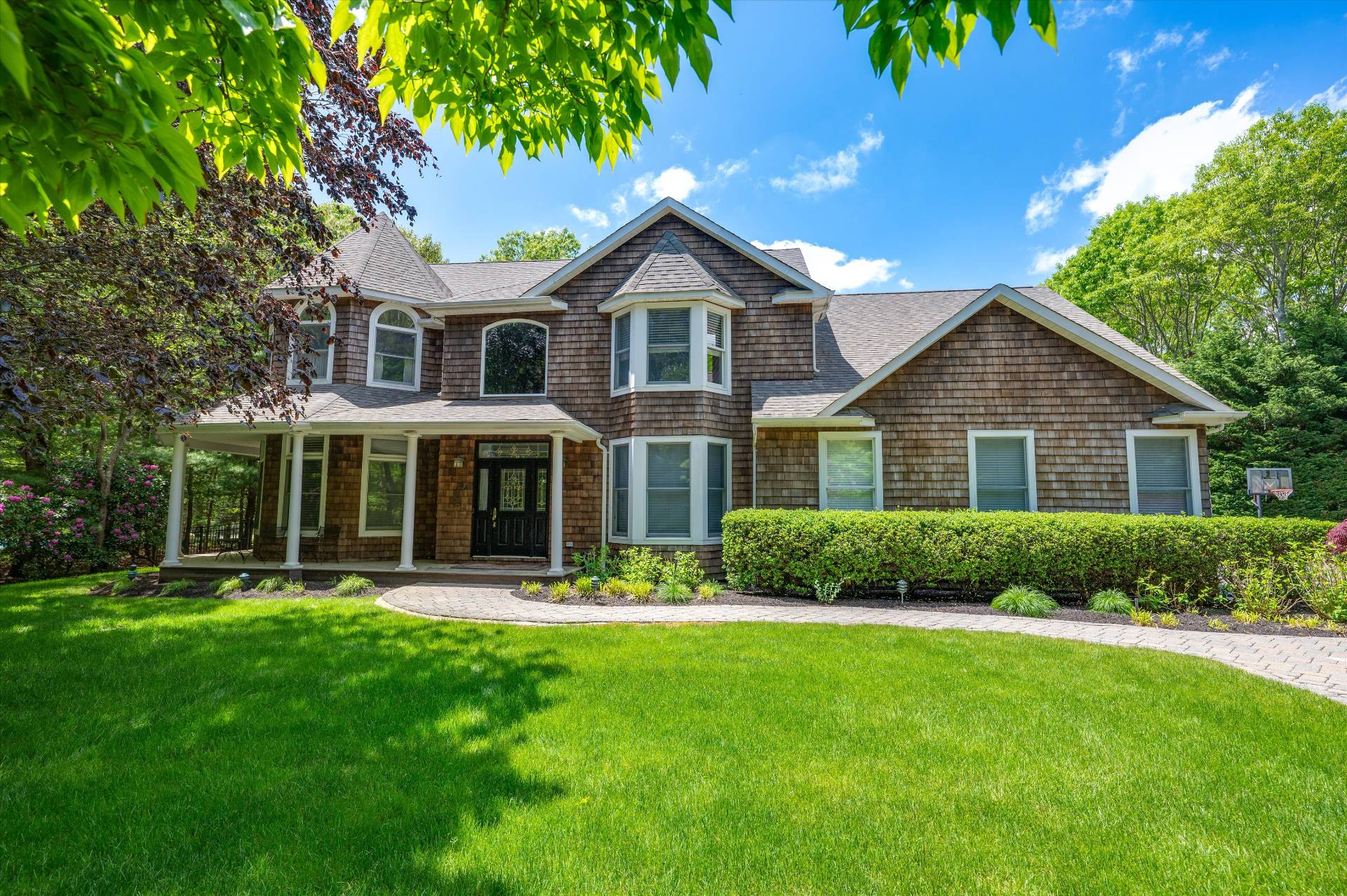 a front view of a house with a yard and trees