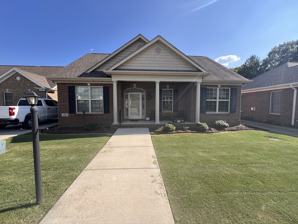 a front view of a house with a yard and porch