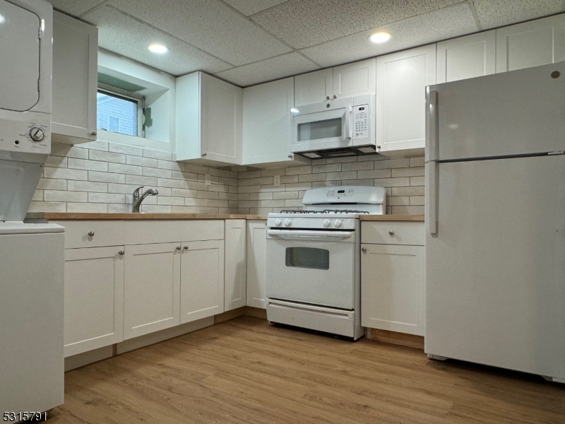 a kitchen with white cabinets and white appliances