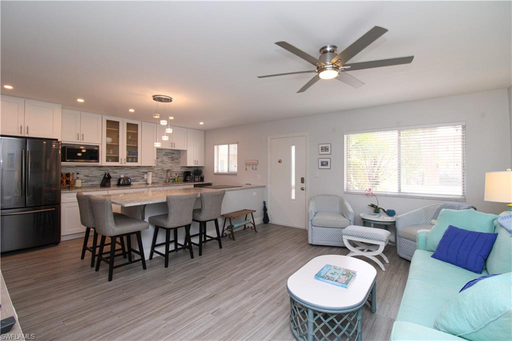 Living room with light hardwood / wood-style floors and ceiling fan