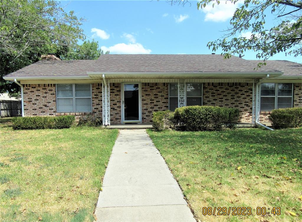 front view of a brick house with a yard