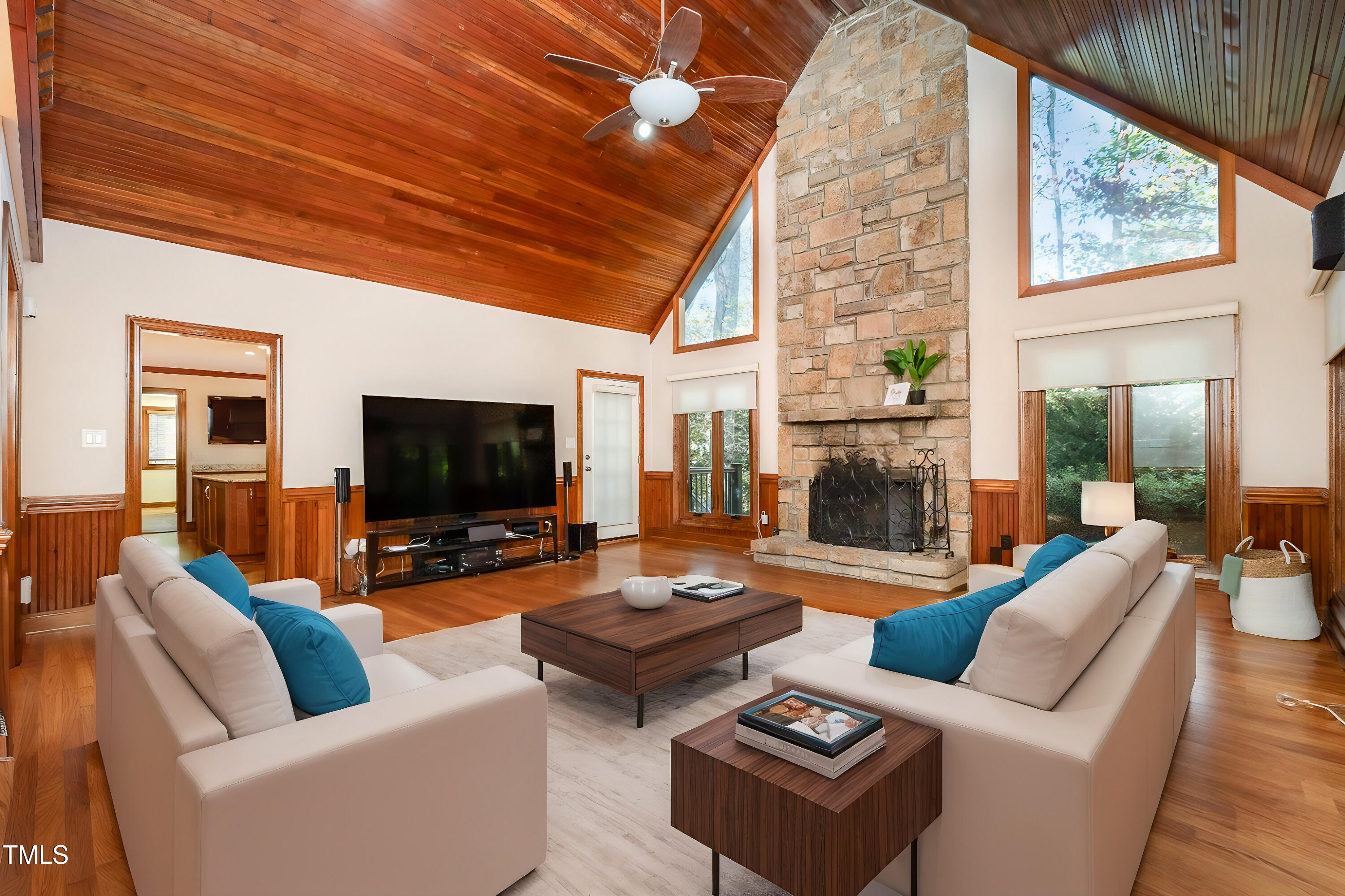 a living room with furniture a flat screen tv and a fireplace