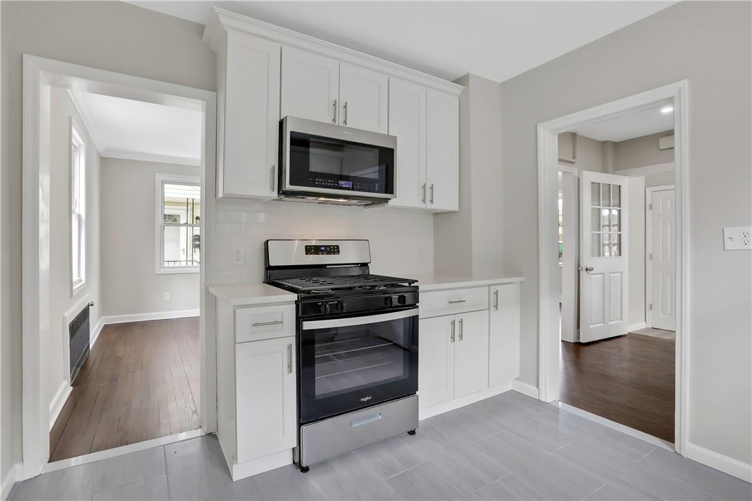 a kitchen with white cabinets and stainless steel appliances