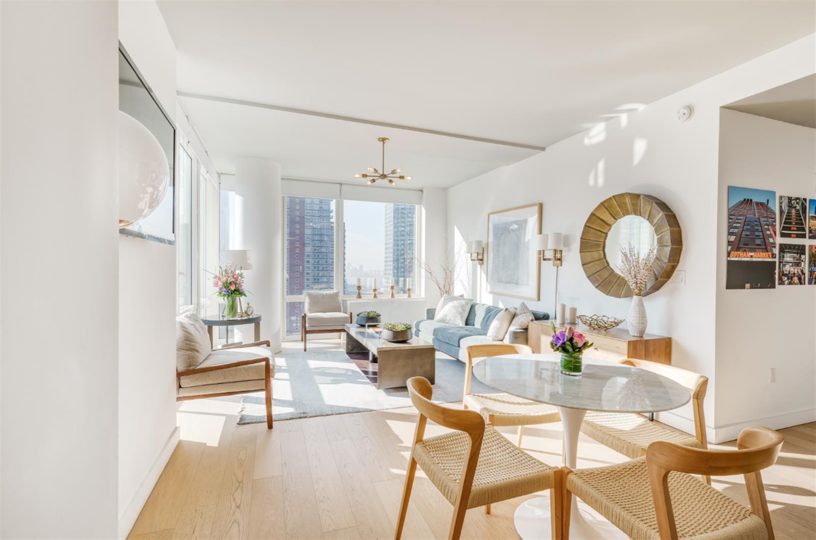 a living room with couches a mirror and a table with wooden floor