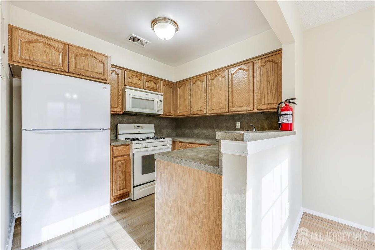 a kitchen with stainless steel appliances granite countertop a refrigerator a stove a sink and a cabinets