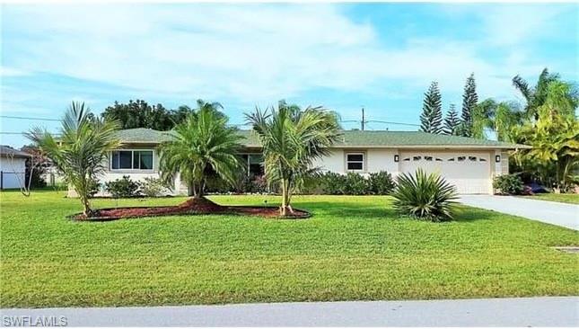 Ranch-style house featuring a garage and a front lawn