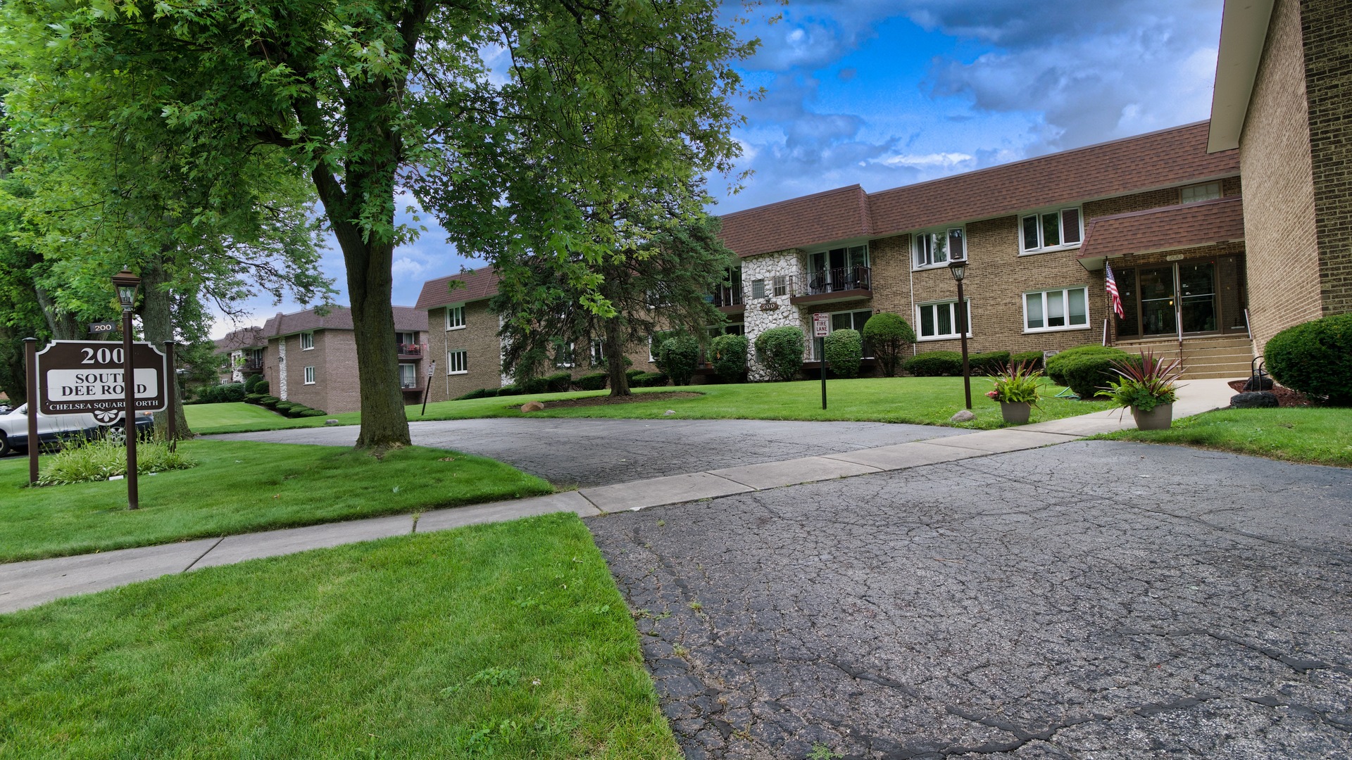 a view of a big house with a big yard and large trees