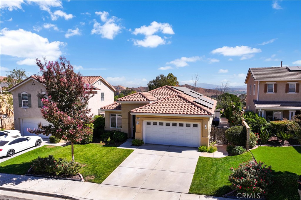 a view of a house with a yard and potted plants