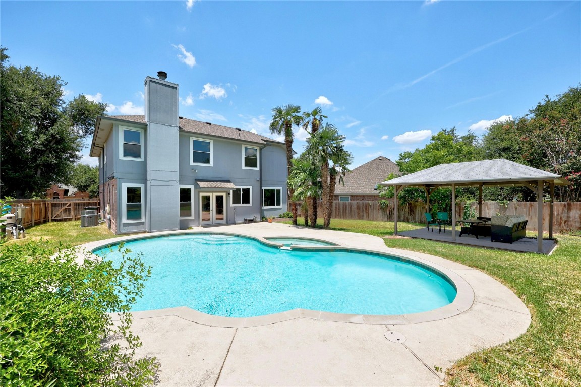 Backyard oasis with a pool and relaxation area.