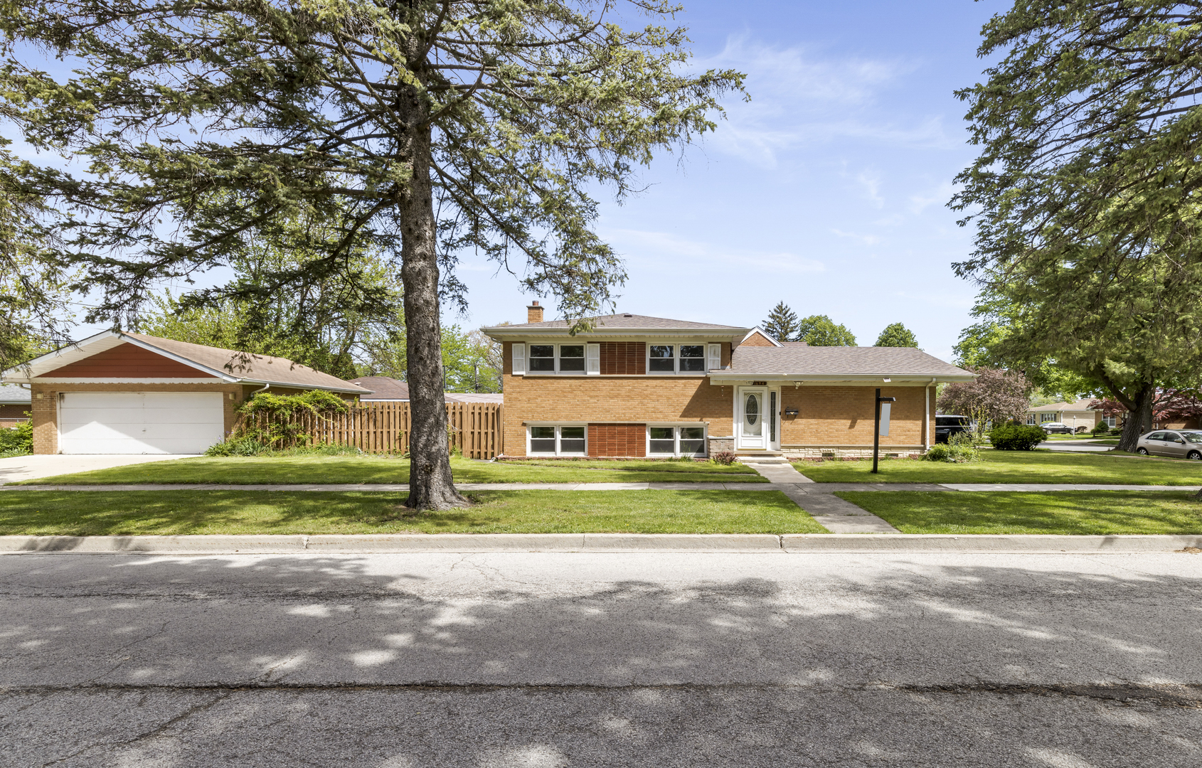 a front view of a house with a yard and trees