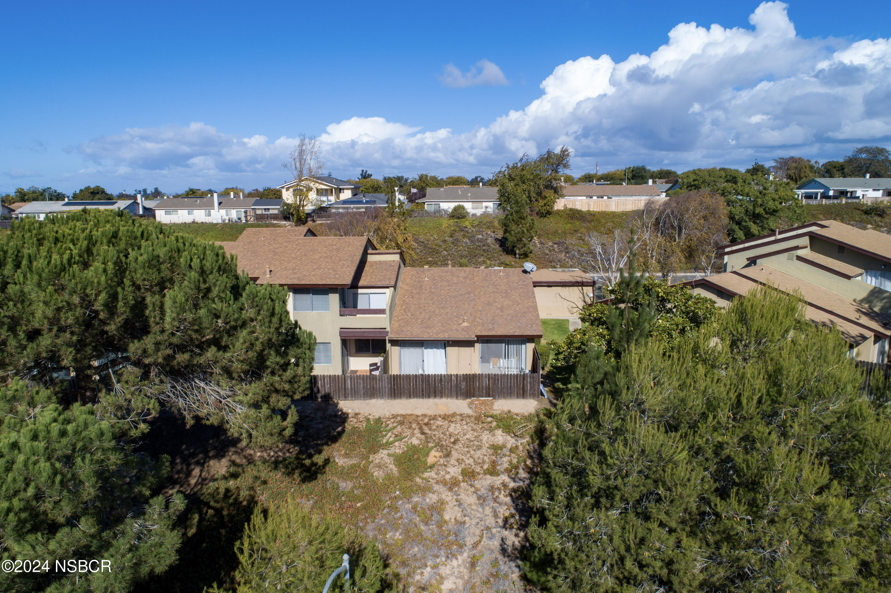 an aerial view of residential houses with outdoor space and trees