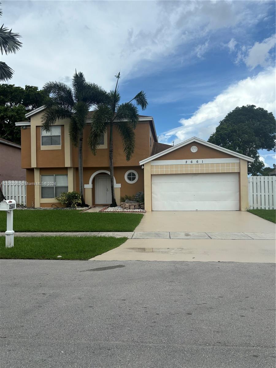 a front view of a house with a yard and garage