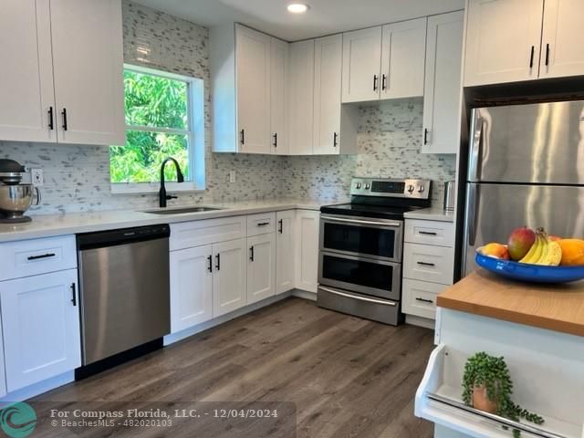 a kitchen with stainless steel appliances a stove a sink and a refrigerator