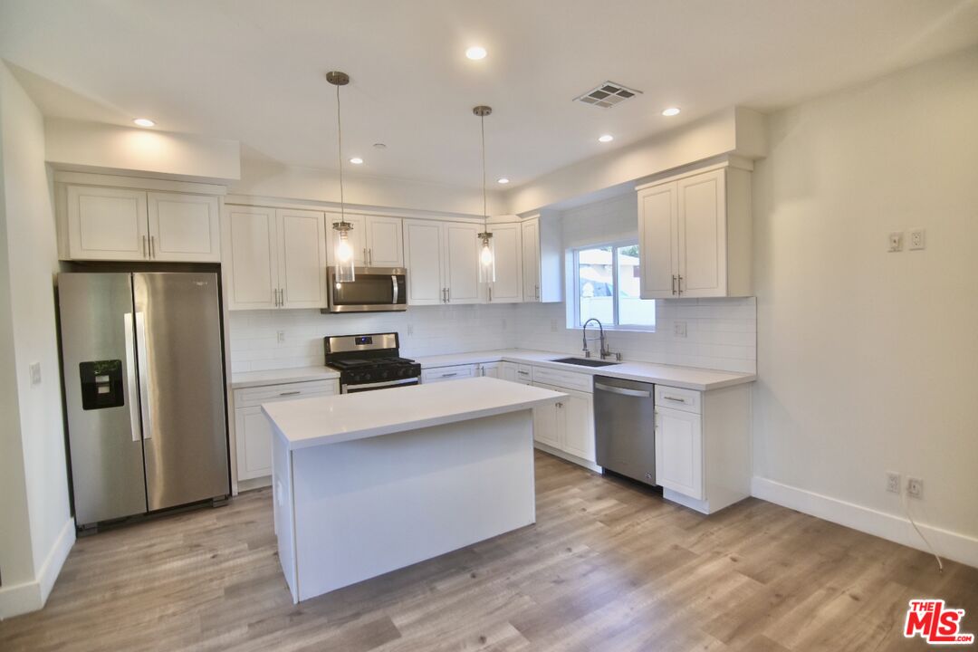 a kitchen with a refrigerator and a sink