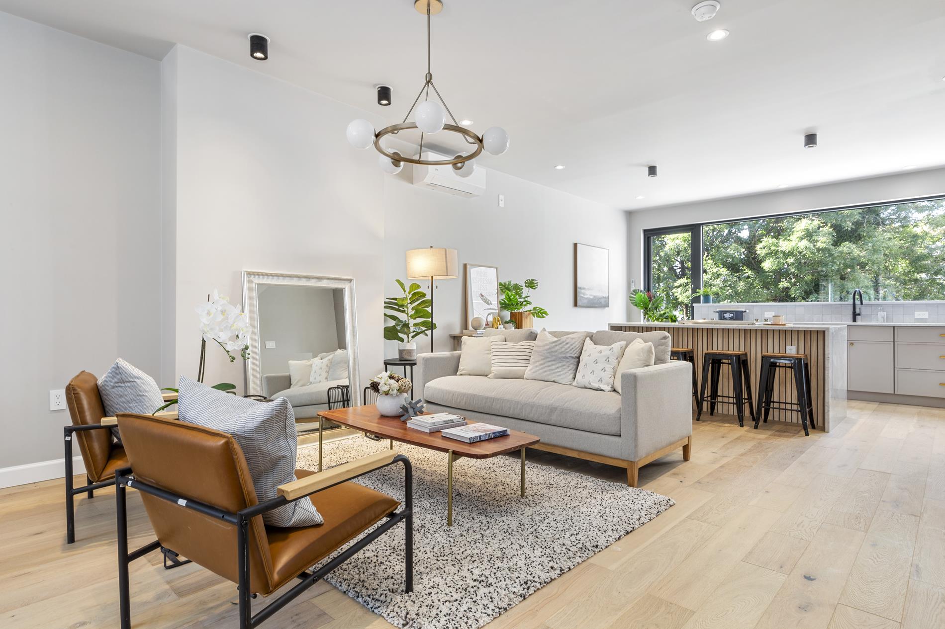 a living room with furniture chandelier and a large window