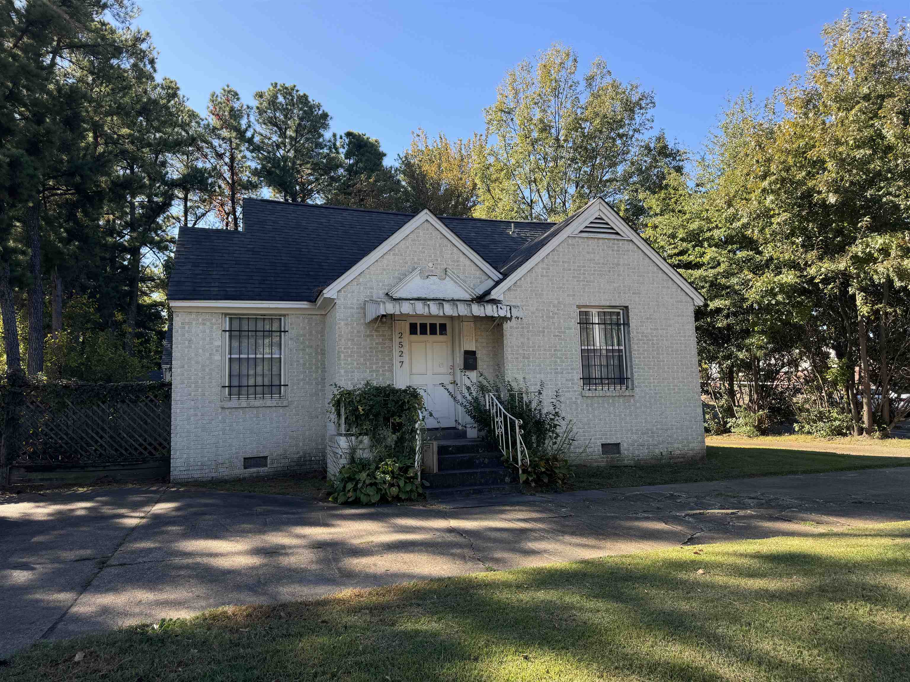 a front view of house with yard and trees in the background