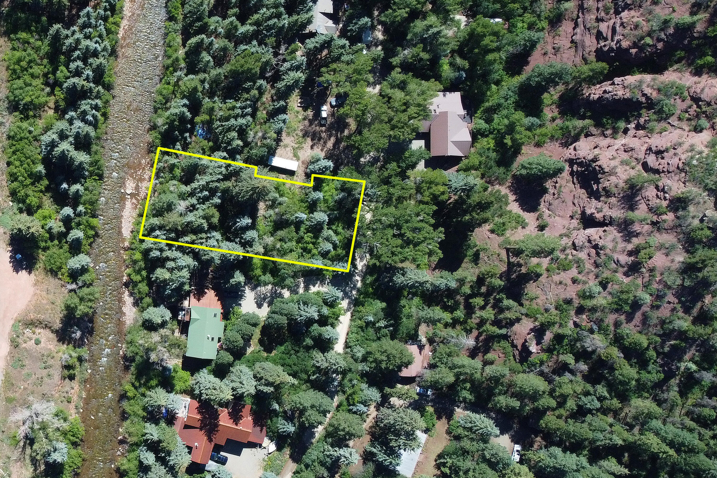 an aerial view of a house with a yard and large trees