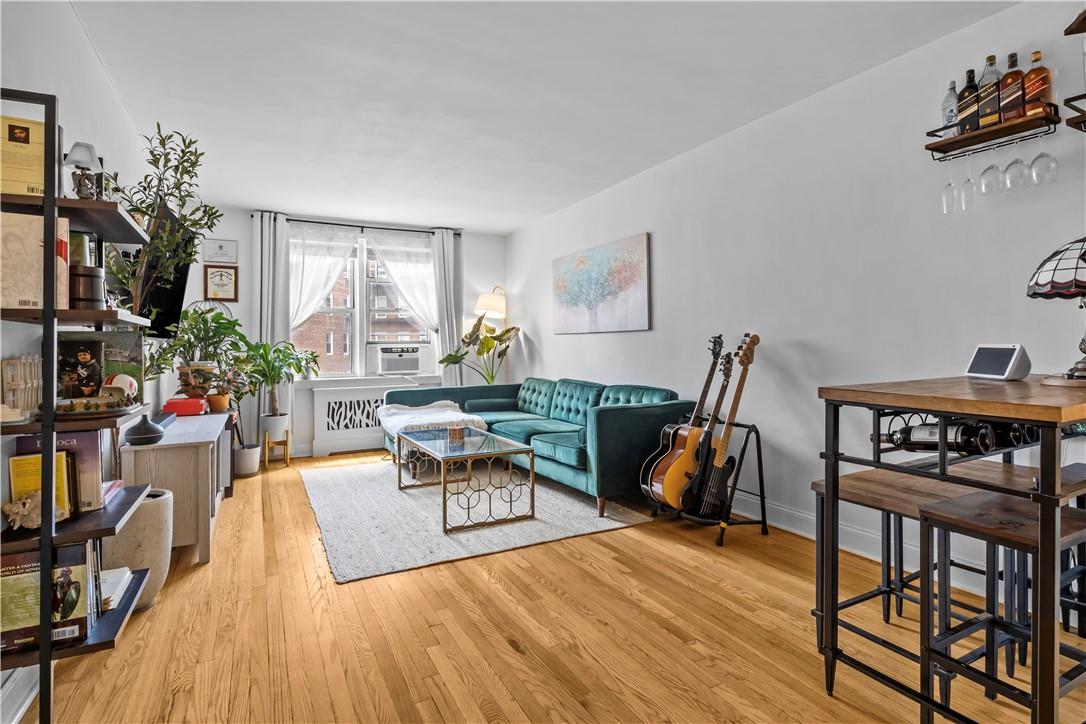 Living room with cooling unit and light wood-type flooring