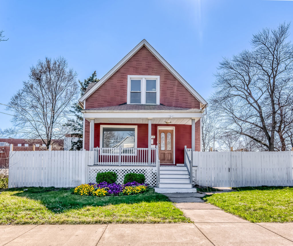 a front view of a house with a yard and fence