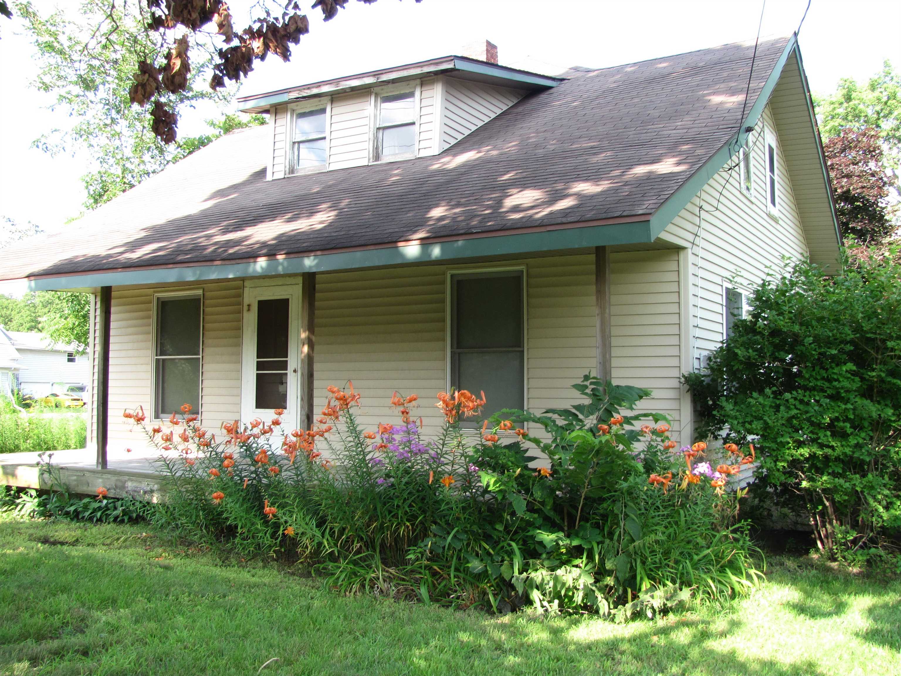 a front view of house with a garden