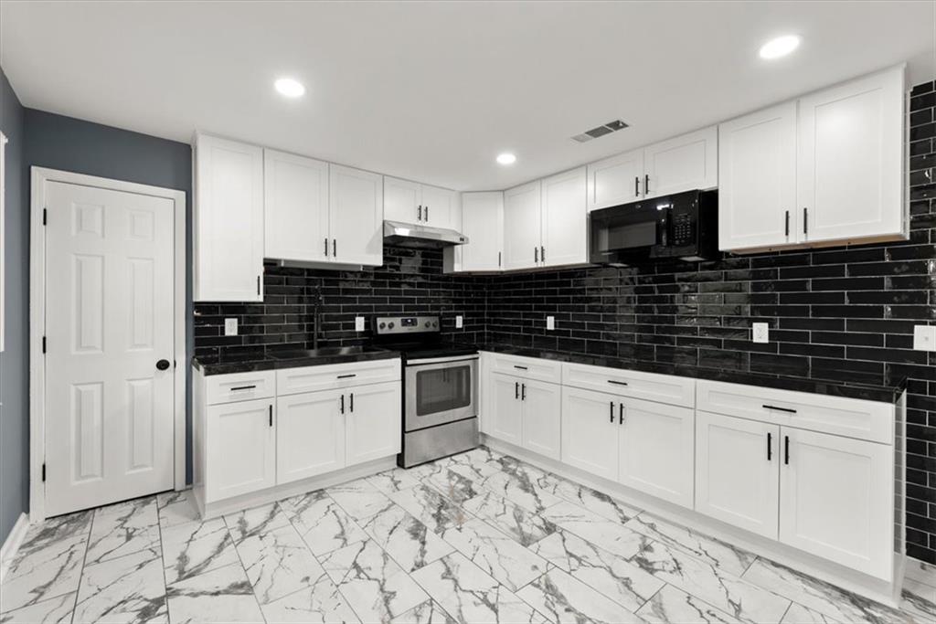 a kitchen with granite countertop white cabinets and sink