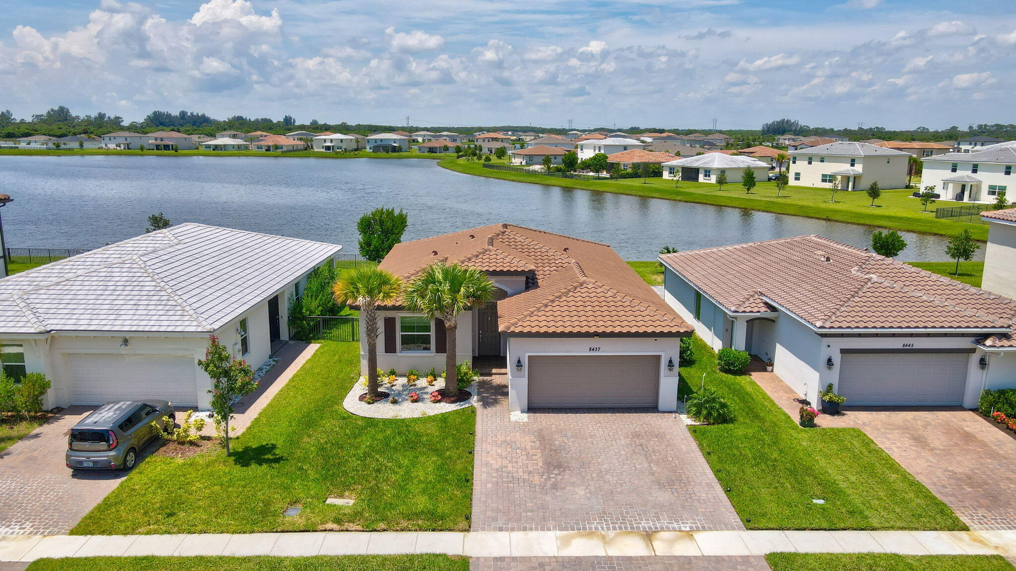 an aerial view of a house with a yard and a large tree