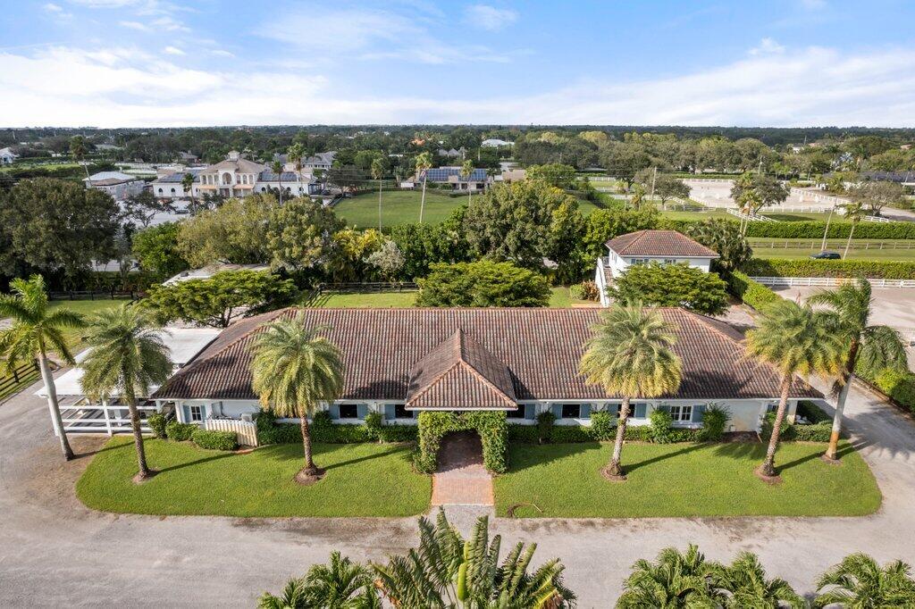 an aerial view of a house with outdoor space and a lake view in back