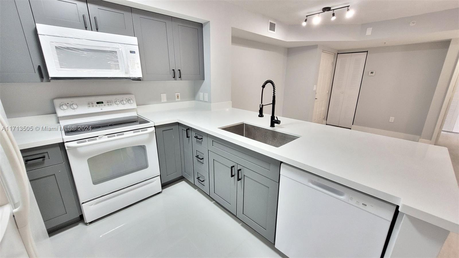 a kitchen with white cabinets sink and stove