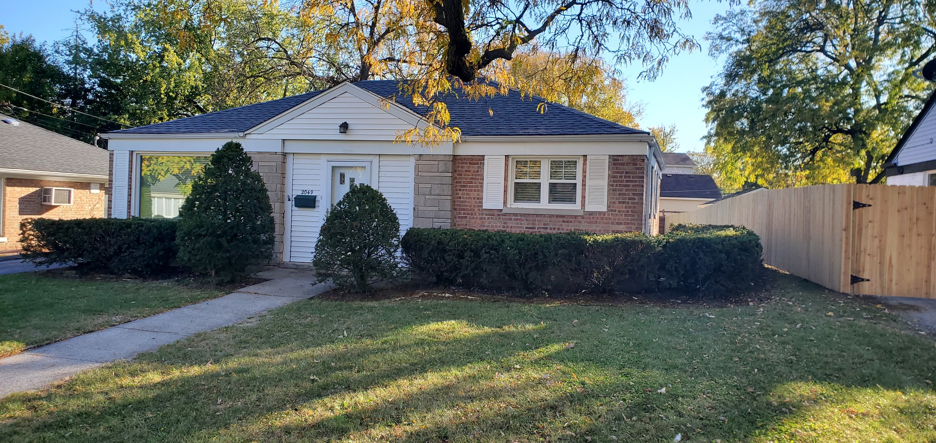 a front view of a house with a garden and yard