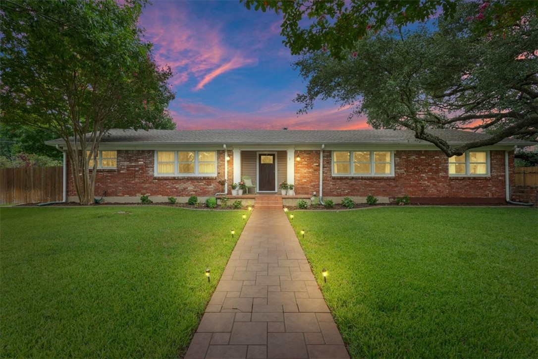 a front view of a house with a garden and yard