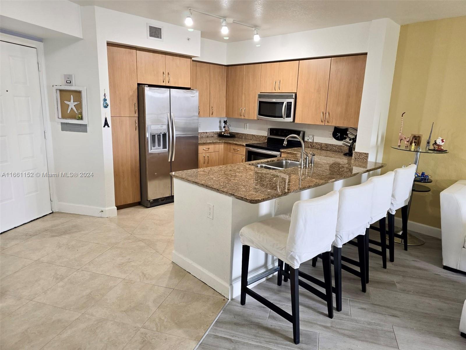 a kitchen with kitchen island a refrigerator stove microwave and cabinets