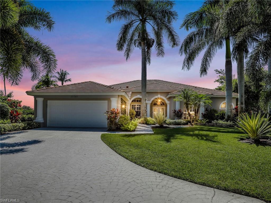 View of front of property with a garage and a yard