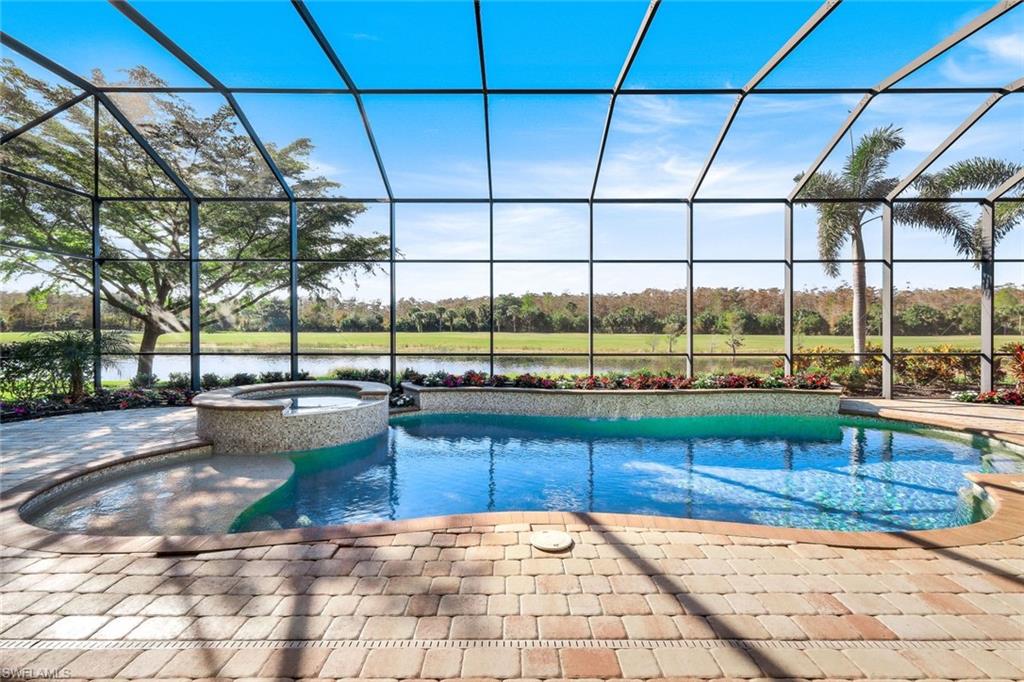 View of swimming pool with a patio, a lanai, an in ground hot tub, and a water view