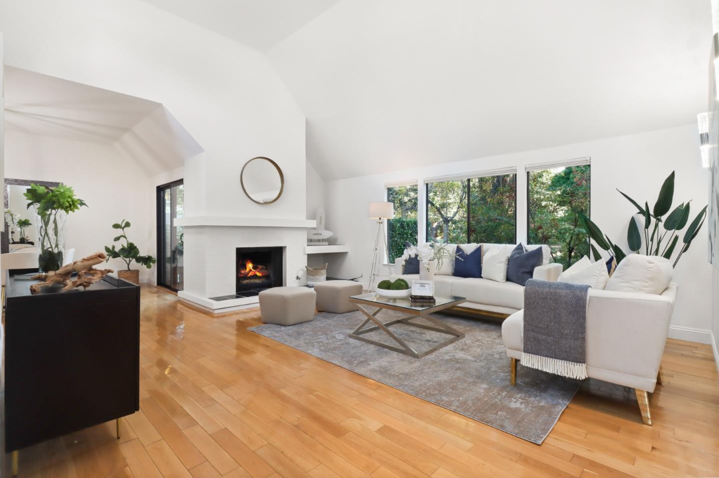 a living room with furniture a large window and a fireplace