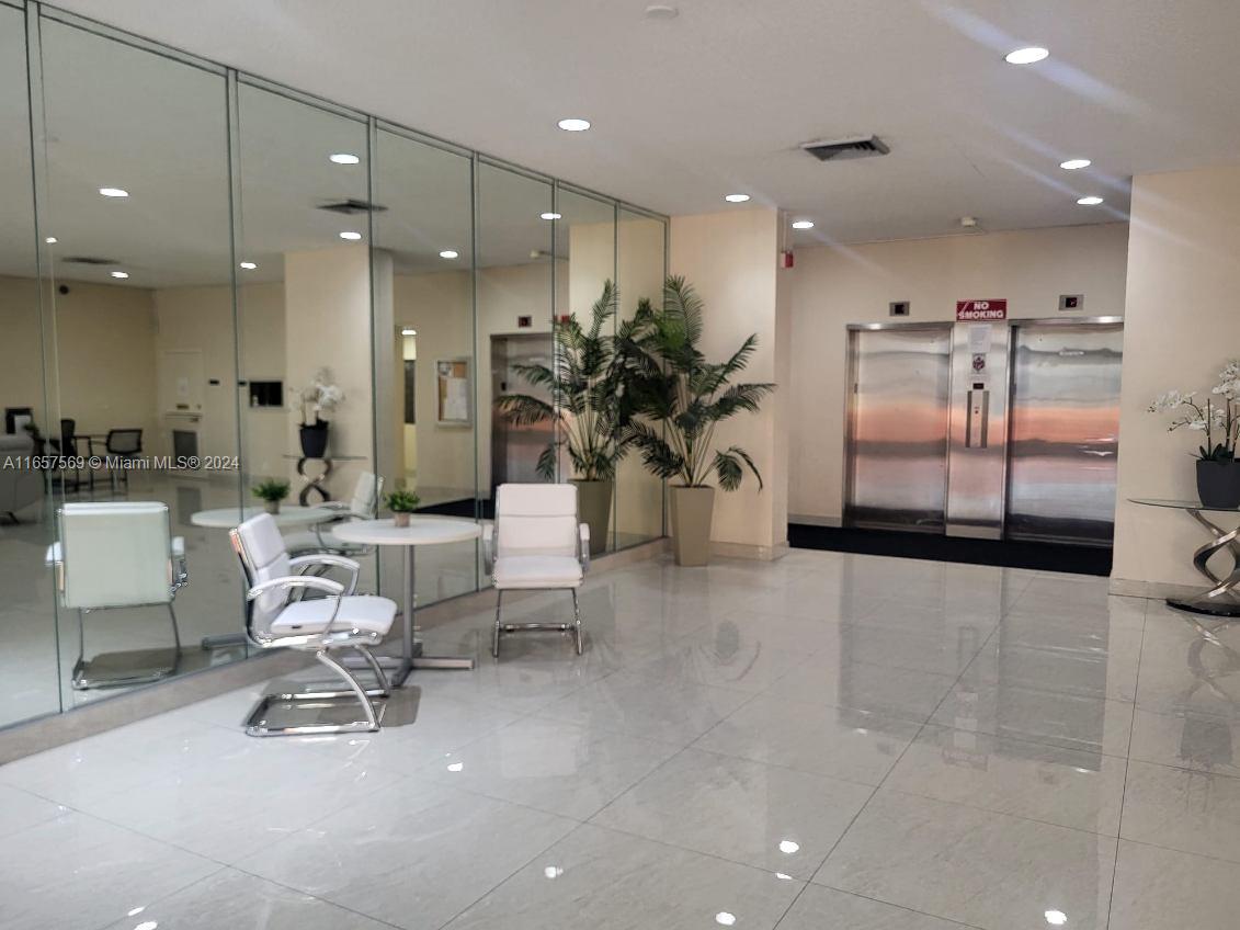 a lobby with furniture and a large mirror