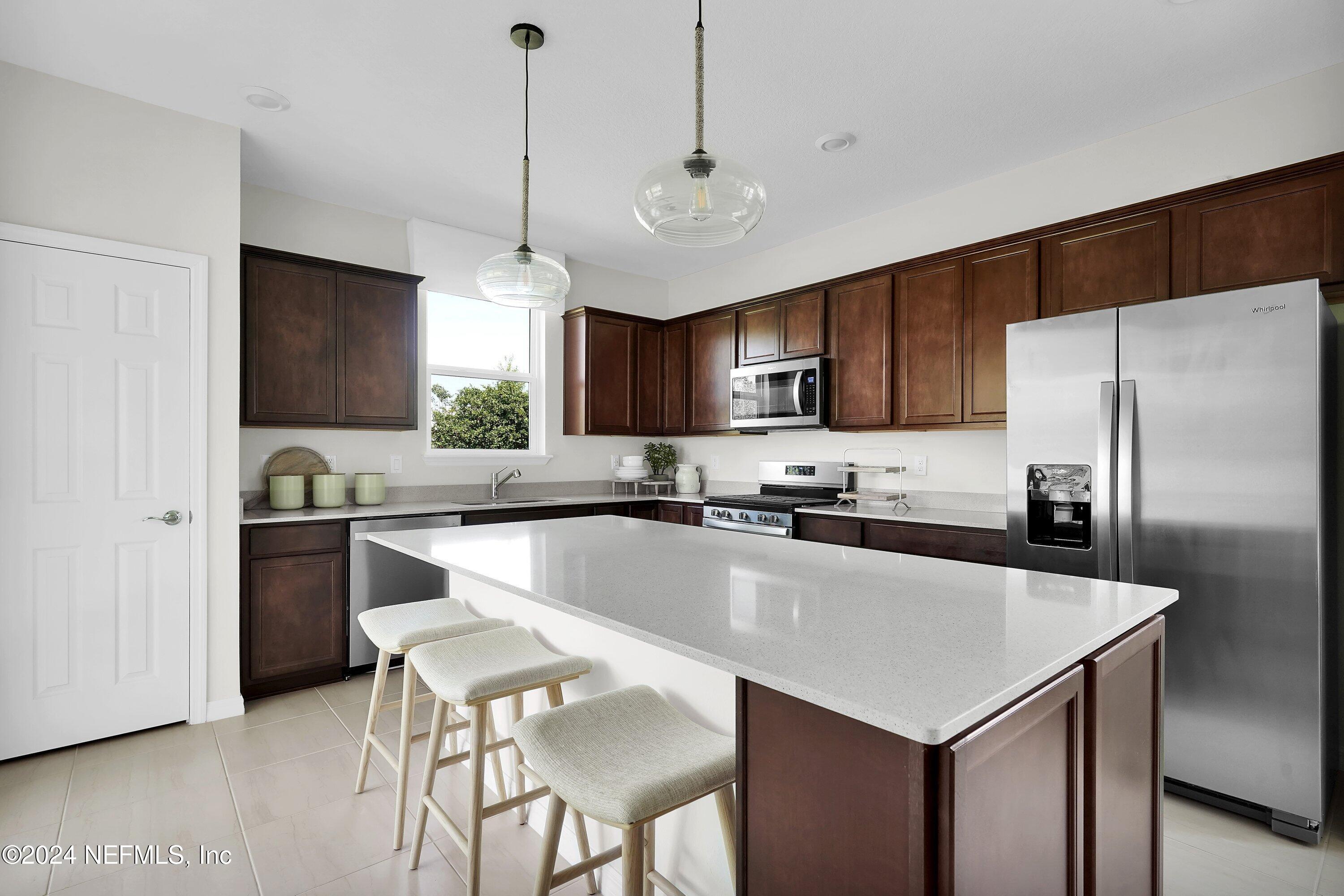 a kitchen with a center island a counter space stainless steel appliances and cabinets