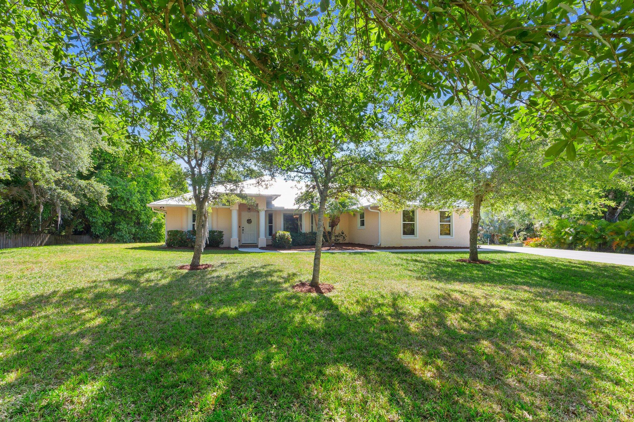 a house with a big yard and large trees