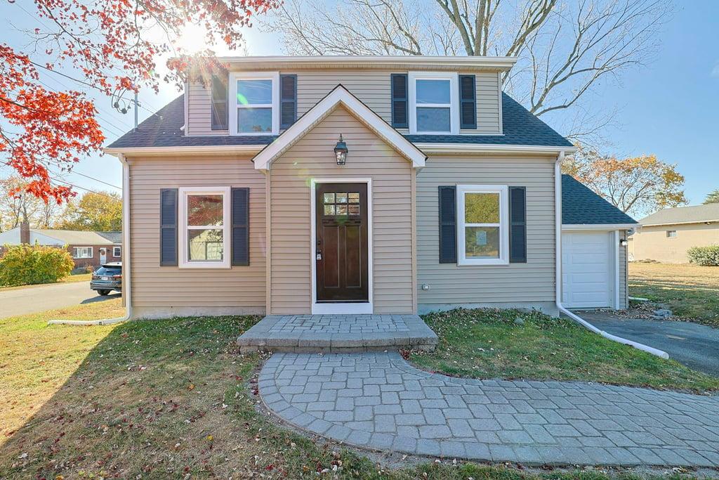 View of front of property featuring a garage and a front yard