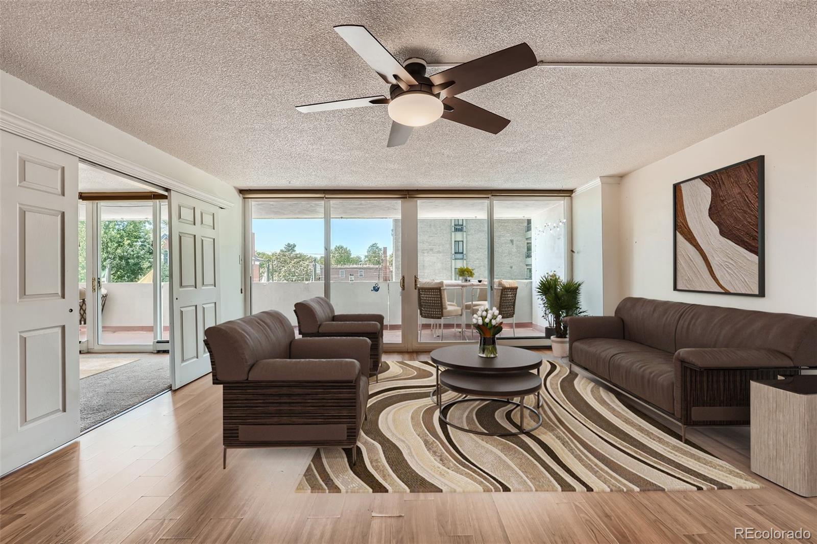 a living room with furniture and a large window with wooden floor