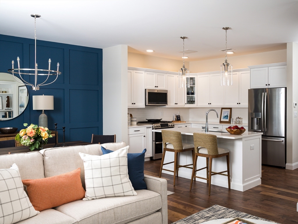 a living room with furniture a flat screen tv and kitchen view