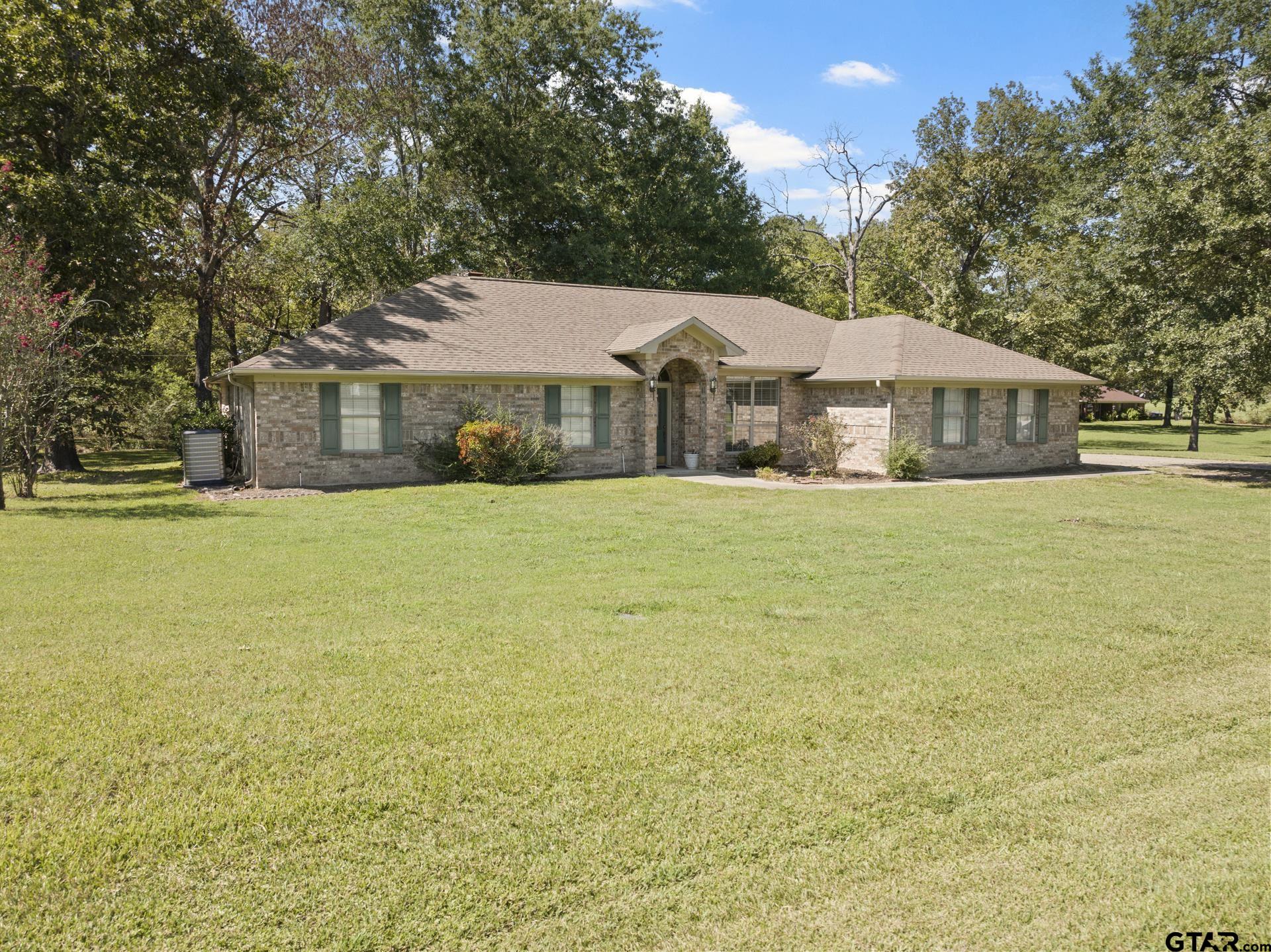 a front view of house with yard and trees