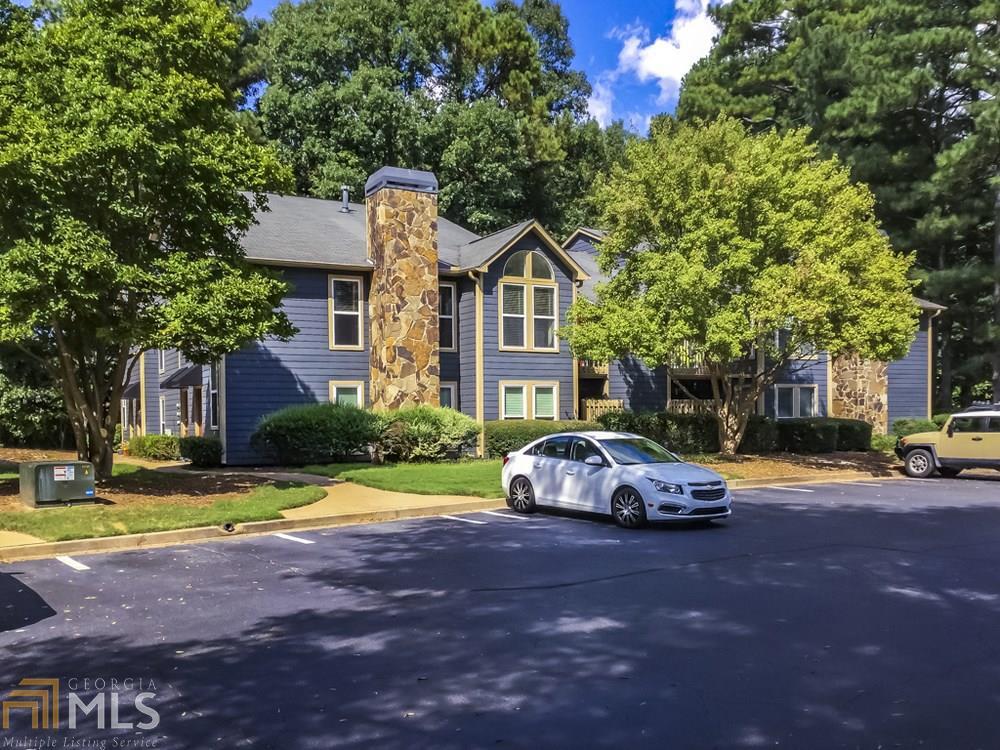 a car parked in front of a house next to a yard