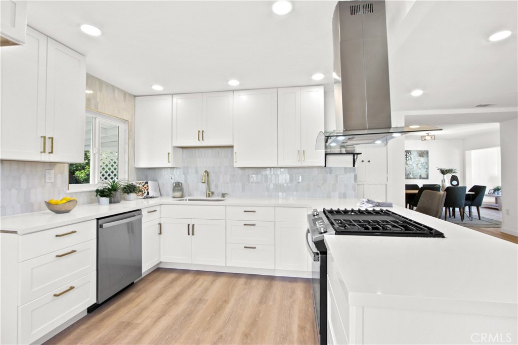 a kitchen with stainless steel appliances a sink stove and cabinets