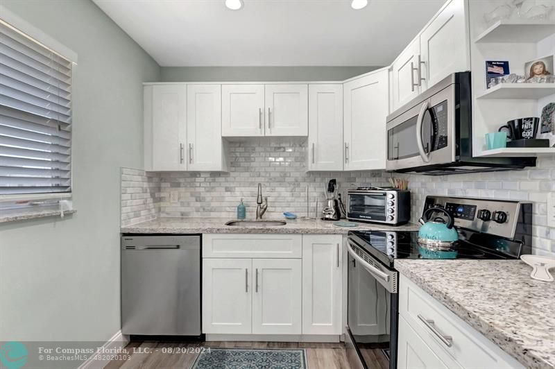 a kitchen with stainless steel appliances granite countertop a stove sink microwave and cabinets