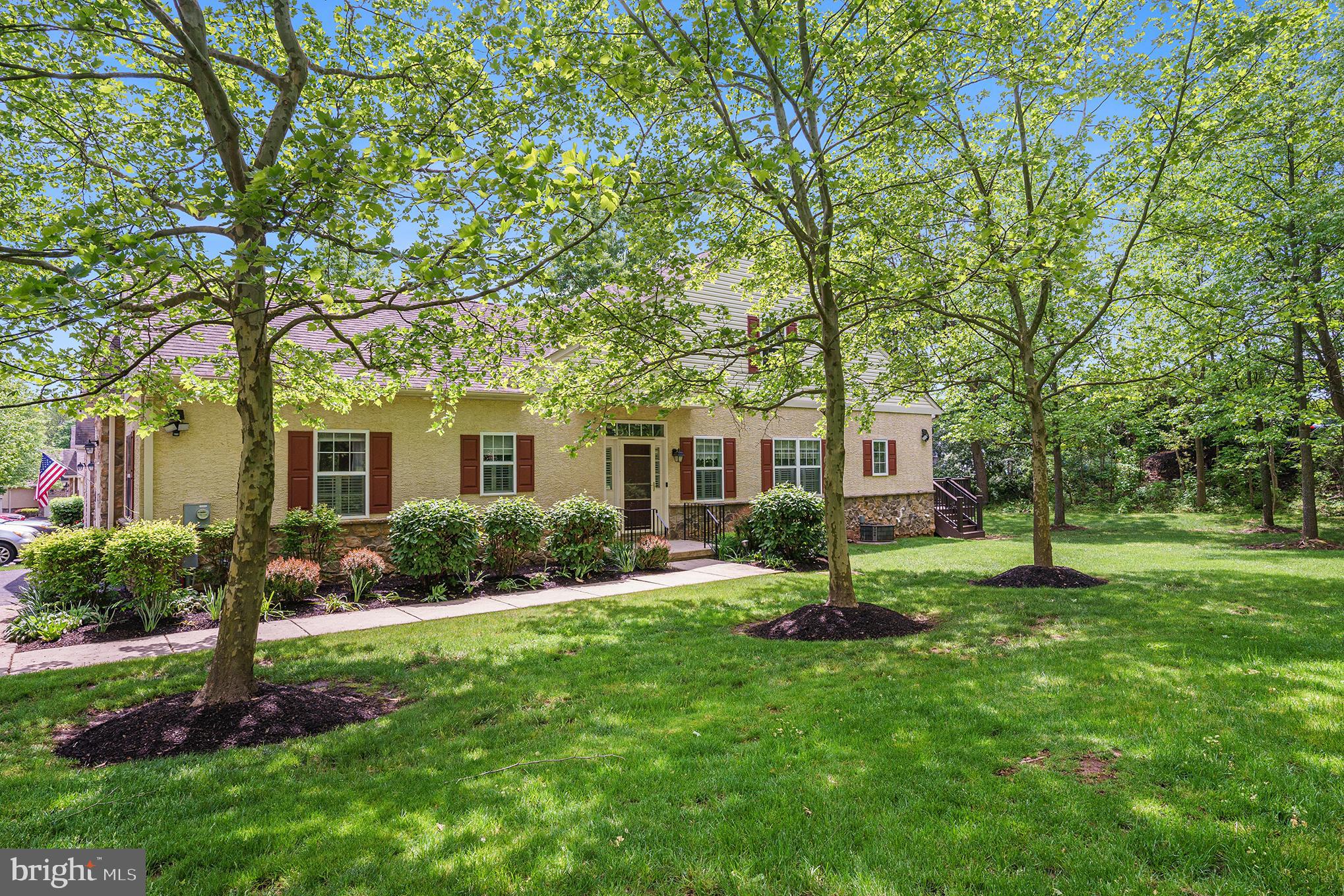 a front view of a house with a yard and large tree