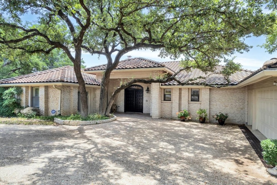 a front view of a house with a yard and potted plants