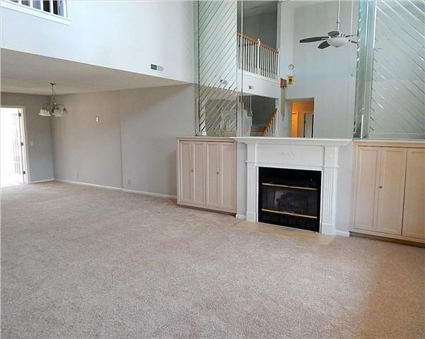 an empty room with a fireplace and entryway