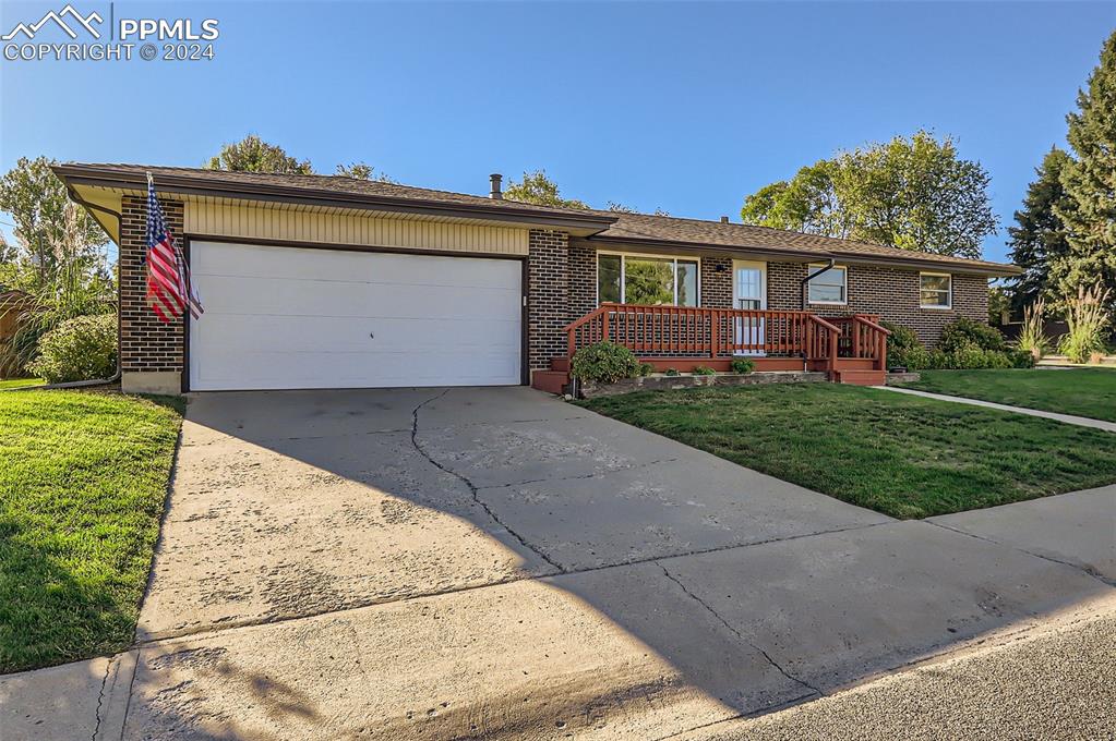 Single story home with a garage and a front yard