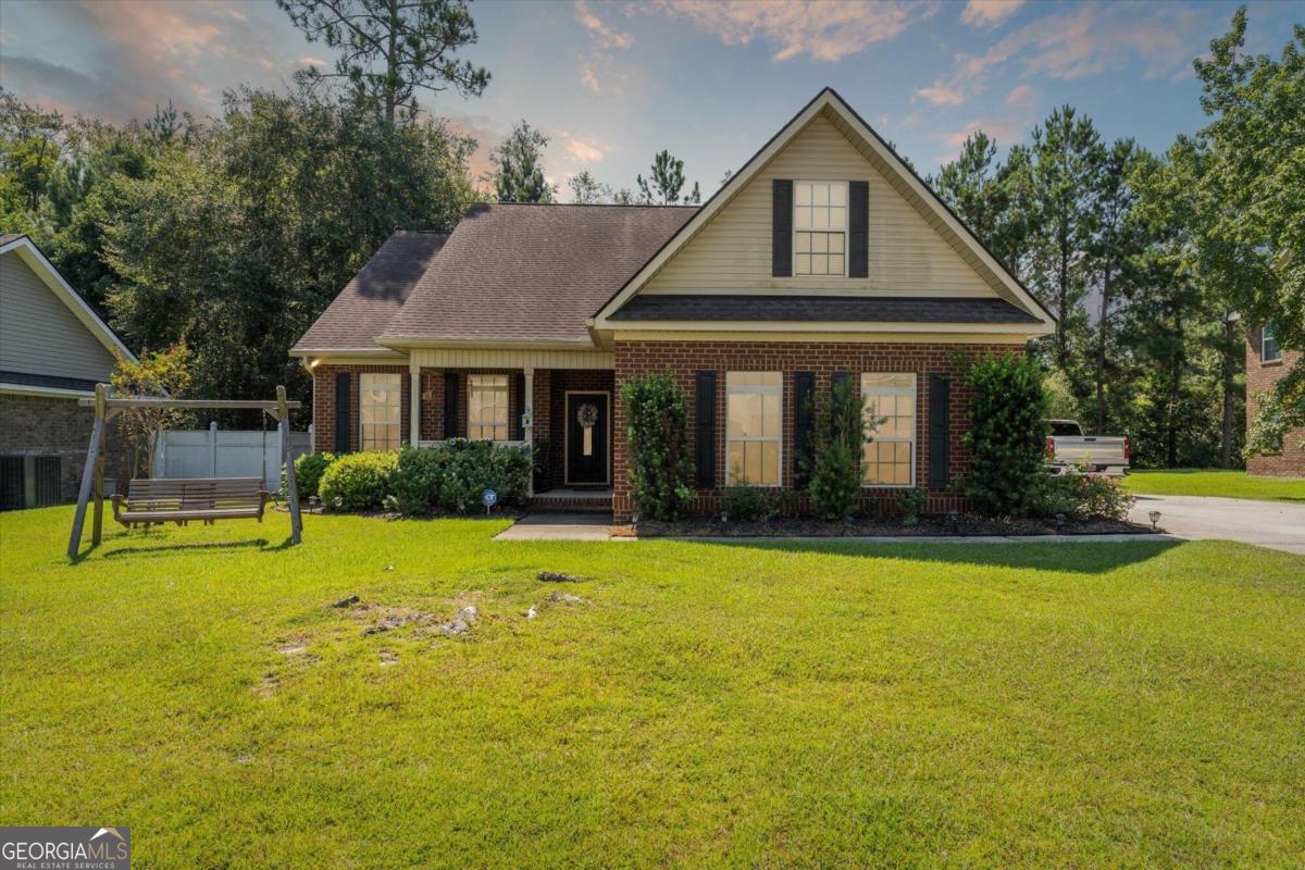 a front view of a house with yard and green space