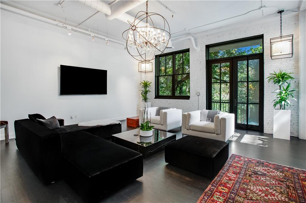 a living room with furniture potted plant and a large window